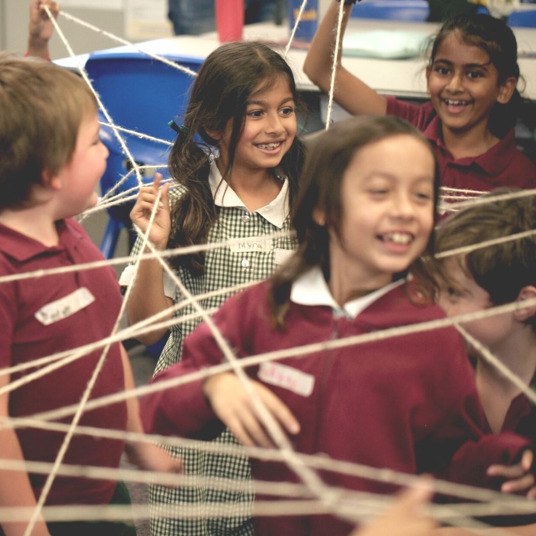 Children in classroom use string to understand shapes