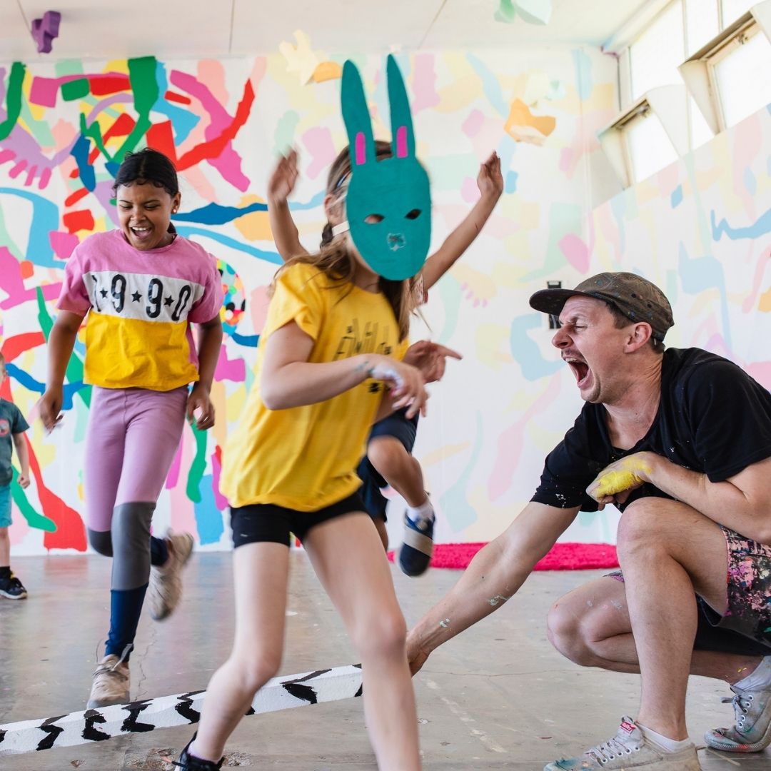 Artist Arlon Hall playing with children wearing masks in the Pom Pom studio