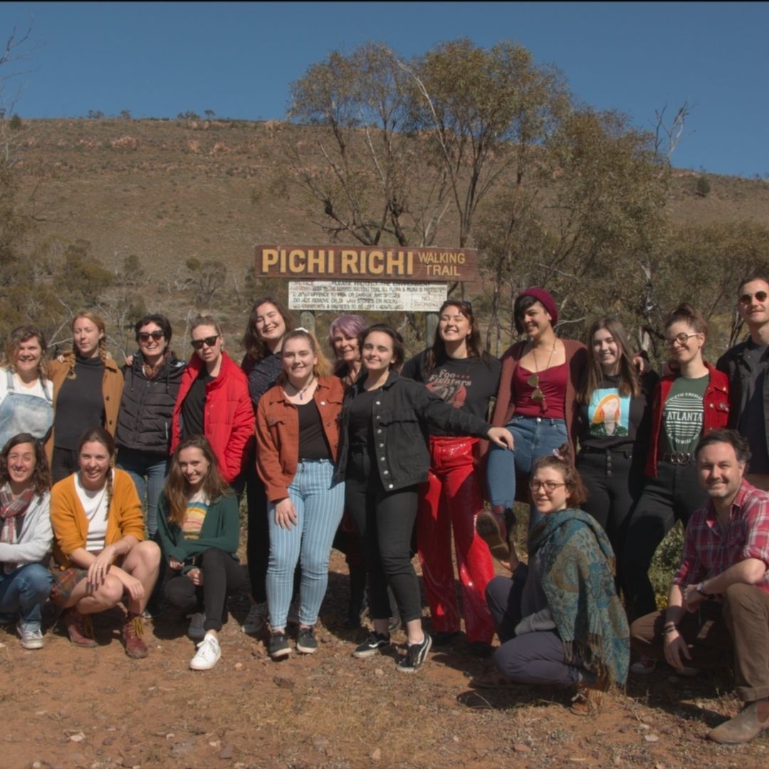 A group of writers standing in front of a sign reading Pichi Richi