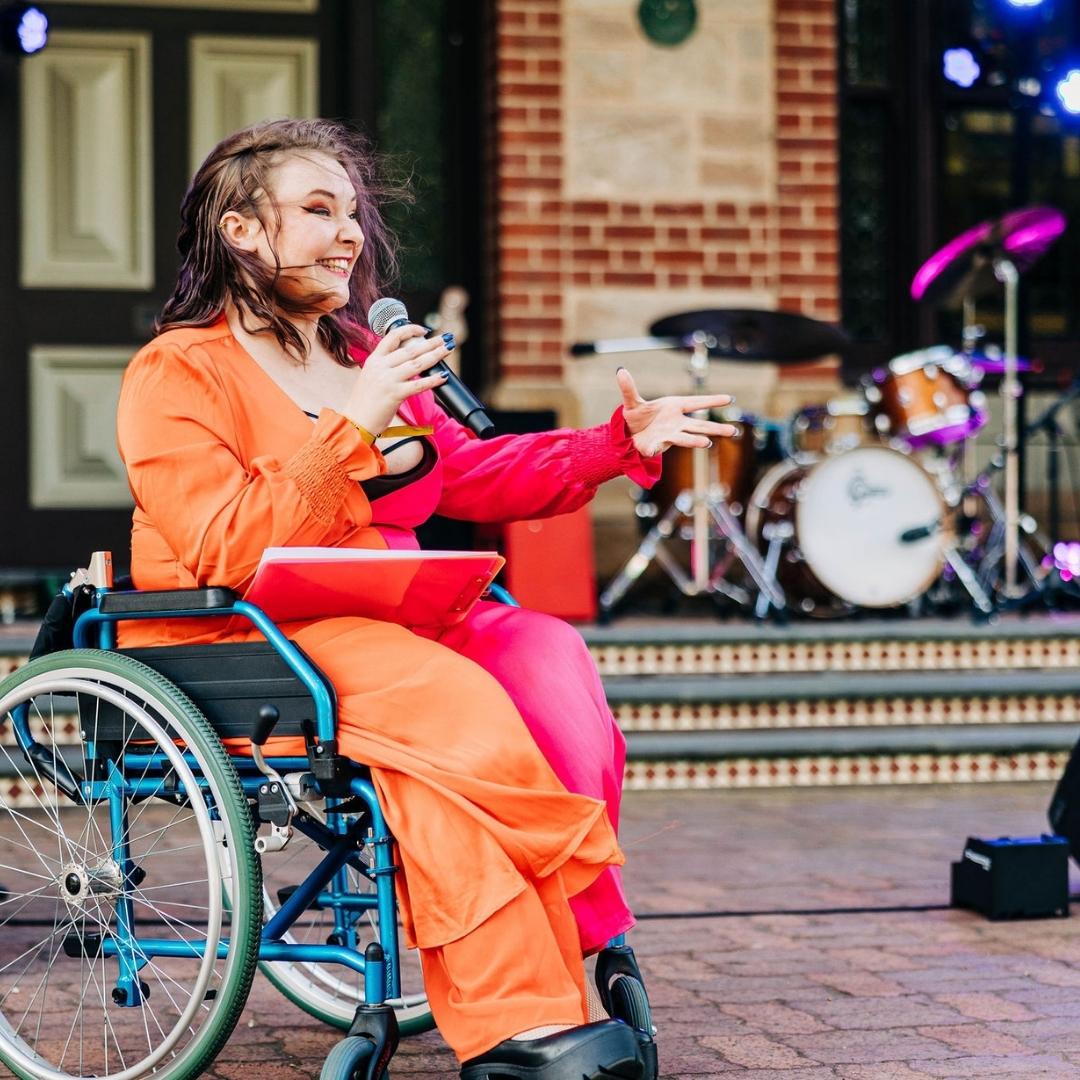 Emerging Creative Producer Diana Devine in her wheelchair MCing Backyard Picnic